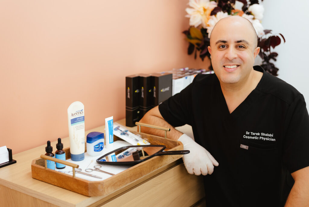 Dr Tarek Shalabi, Cosmetic Physician smiling to the camera in his office.