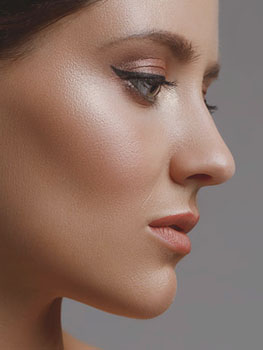 Close up side profile of female model with winged eyeliner and simple makeup. Perfect shaped nose from non-surgical nose filler